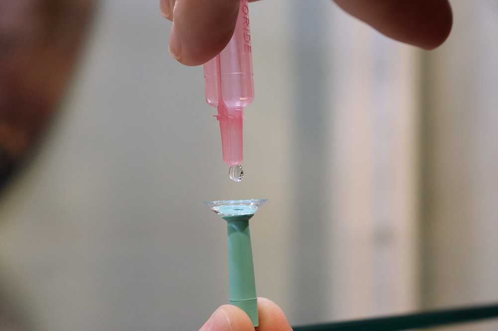 person lubricating contact lens