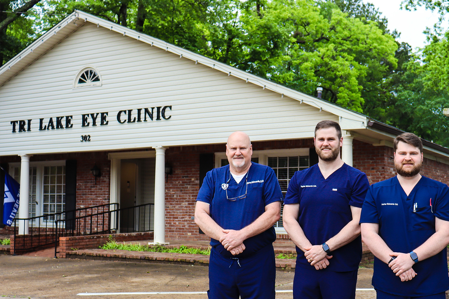 Dr. Steve, Dr. Hunter, and Dr. Taylor Edwards at Tri Lake Eye Clinic – Dr. Taylor Edwards Dr. Steve Edwards, Dr. Hunter Edwards, and Dr. Taylor Edwards stand smiling in front of Tri Lake Eye Clinic. – Dr. Taylor Edwards