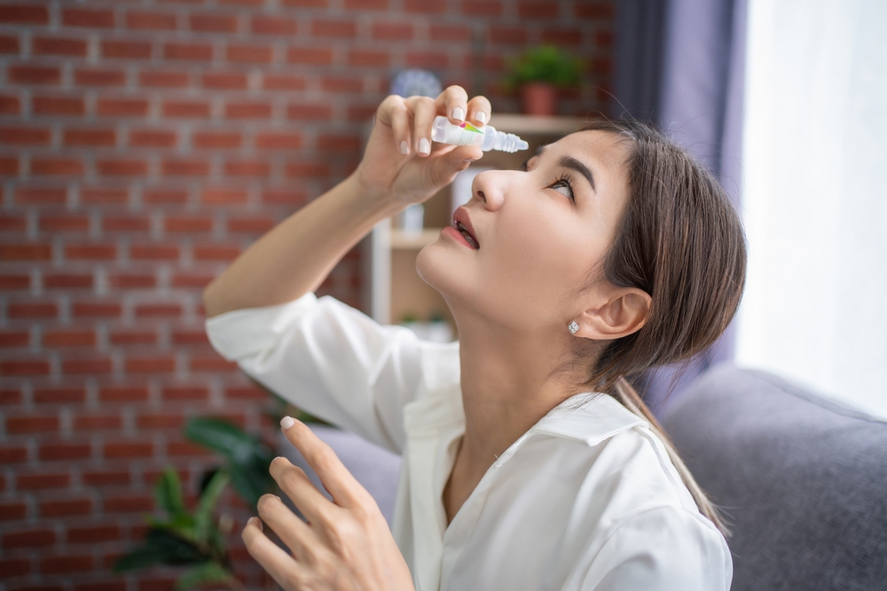 woman putting on eye drops - Dry Eye Treatment in Senatobia